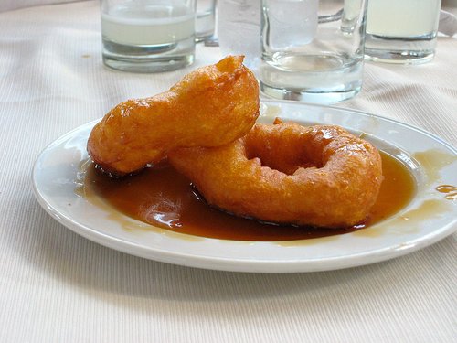 Picarones Peruvian Donuts on Plate with Chancaca Syrup - peruvian dessert