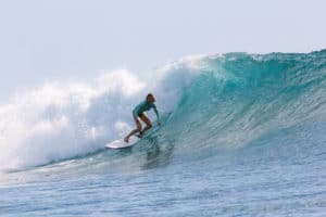 Woman surfing a wave in Mancora Peru surf resort